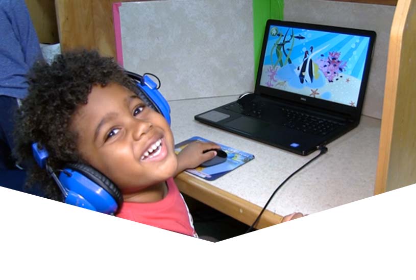 Boy playing on a laptop during an after school program at Meadowlake Day School